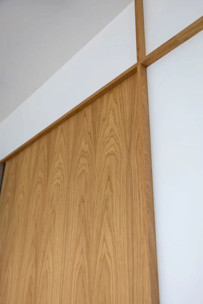 Close view of continuous oak veneer grain across the wall panels
